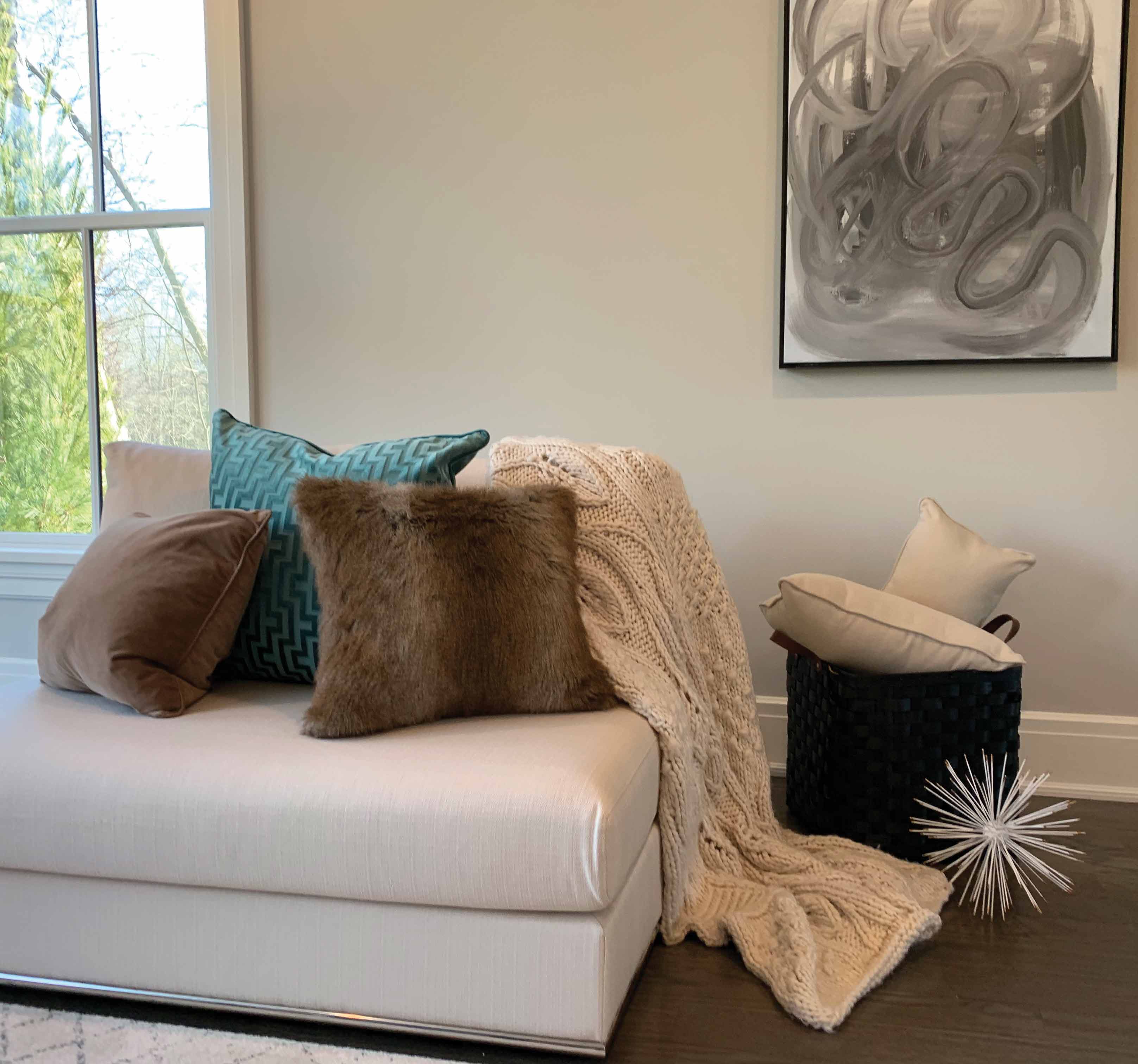 Real Estate Trends an ottoman layered with luxuriuos fabrics