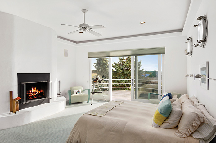 Bedroom with white walls and a fireplace