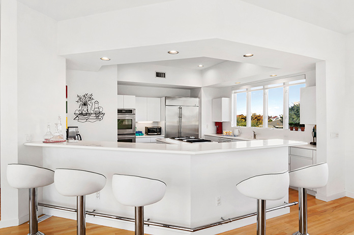 A white kitchen with bar stools