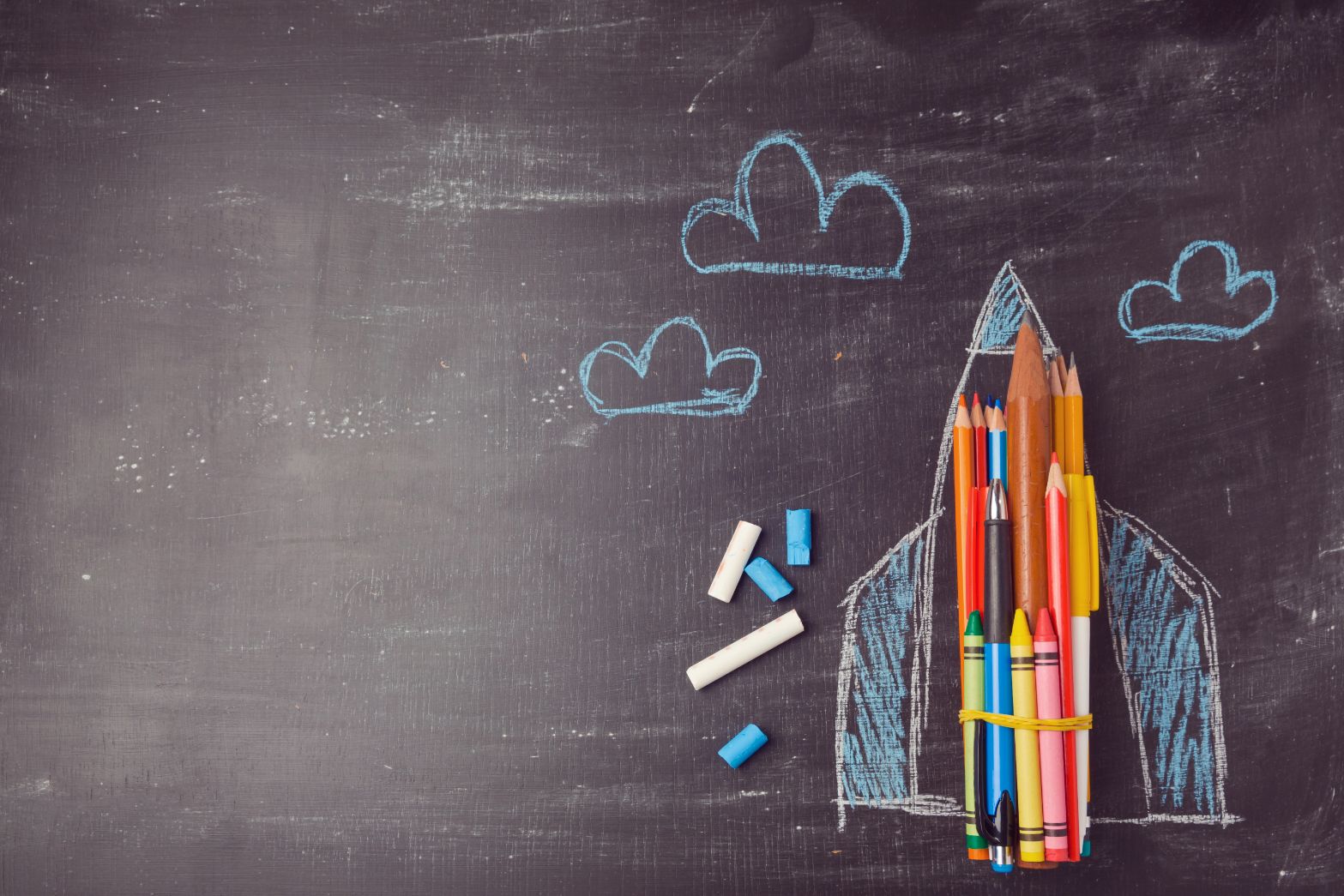 chalkboard with pens and pencils